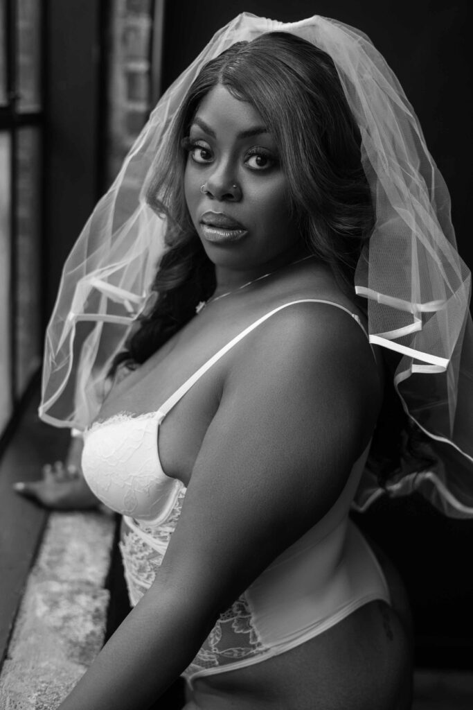 woman gazes into the camera of her Atlanta boudoir photographer for a black and white portrait