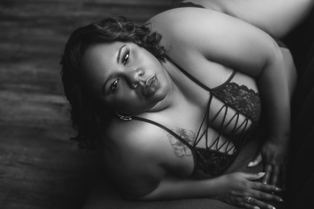 curvy plus size woman looking up while laying on couch during a boudoir shoot